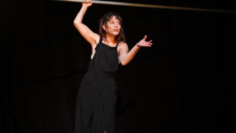 Nadia Ghadang-far sur scène, elle est debout et se tient à une structure en métal.