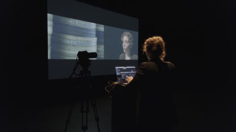 Mila Turajlic faisant face à un écran qui projette l'image qu'elle est en train de filmer.